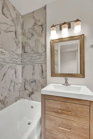 a bathroom with a sink vanity and bathtub