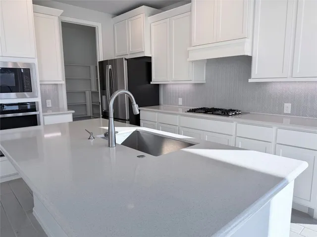 a kitchen with stainless steel appliances granite countertop a sink a stove and a refrigerator with wooden floor