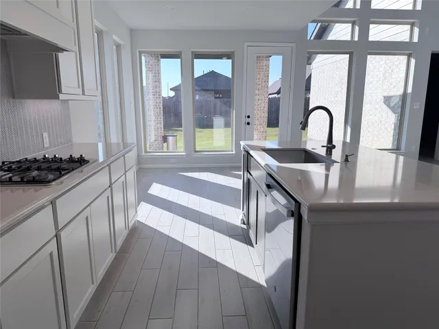 a kitchen with a sink and a stove top oven