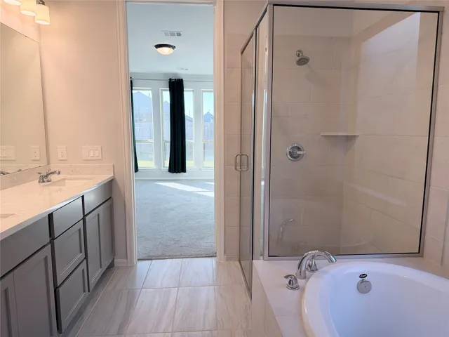 a bathroom with a tub sink and mirror