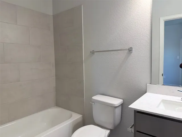 a white toilet sitting next to a bath tub
