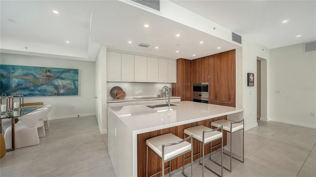 111 Golden Gate Point, Unit 201 Sarasota, FL 34236 - Photo 11 of 64 a kitchen with stainless steel appliances granite countertop a table chairs sink and cabinets