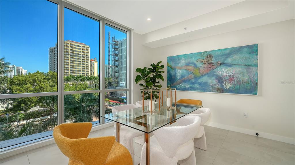 111 Golden Gate Point, Unit 201 Sarasota, FL 34236 - Photo 19 of 64 a dining room with furniture and a floor to ceiling window