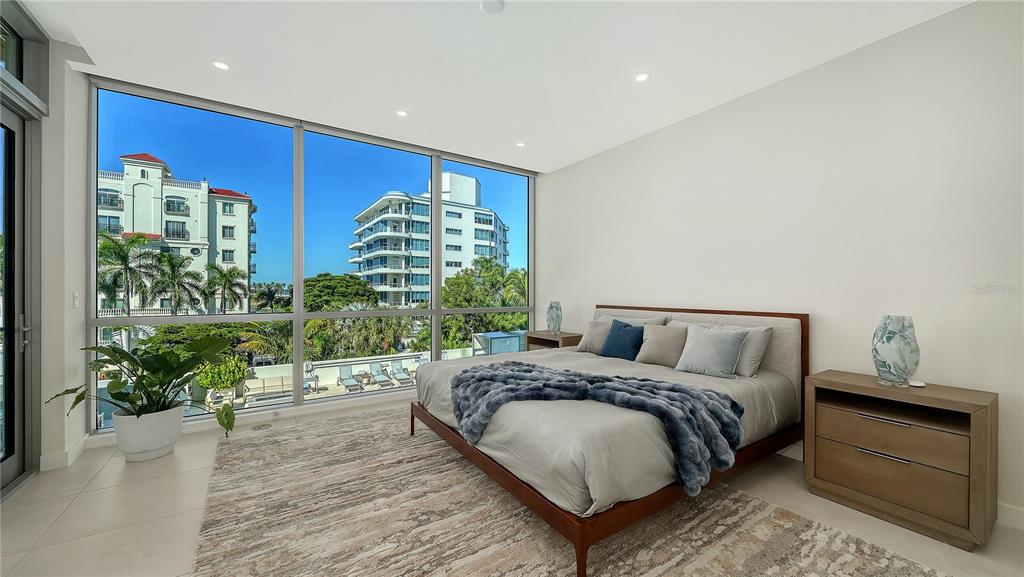 111 Golden Gate Point, Unit 201 Sarasota, FL 34236 - Photo 22 of 64 a spacious bedroom with a bed and a potted plant