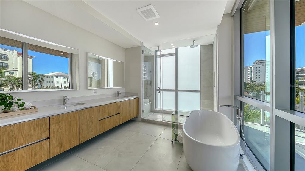 111 Golden Gate Point, Unit 201 Sarasota, FL 34236 - Photo 23 of 64 a spacious bathroom with a granite countertop sink and a large mirror