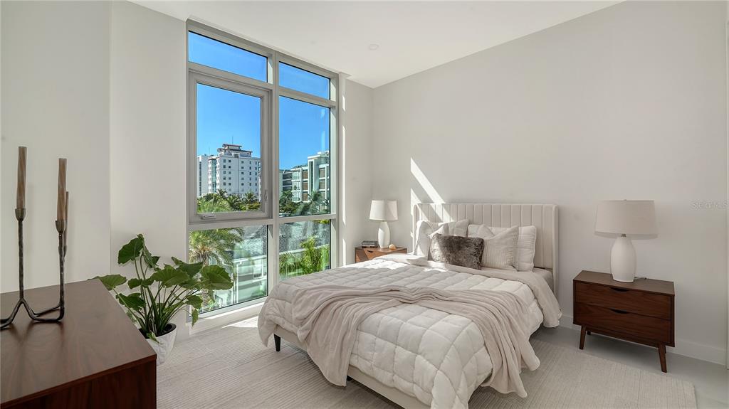 111 Golden Gate Point, Unit 201 Sarasota, FL 34236 - Photo 26 of 64 a bedroom with a bed and a potted plant