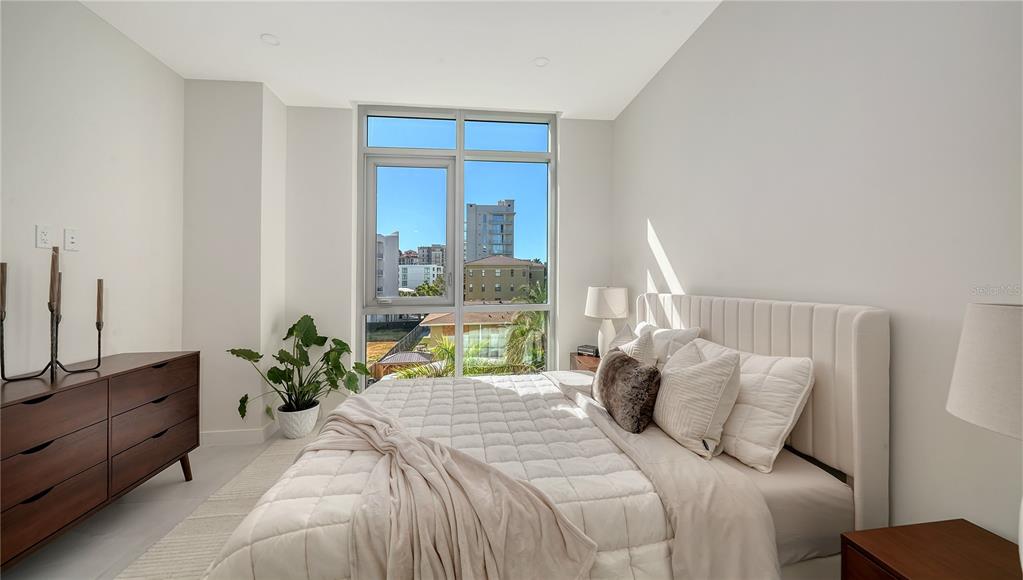 111 Golden Gate Point, Unit 201 Sarasota, FL 34236 - Photo 27 of 64 a bedroom with a bed and a large window