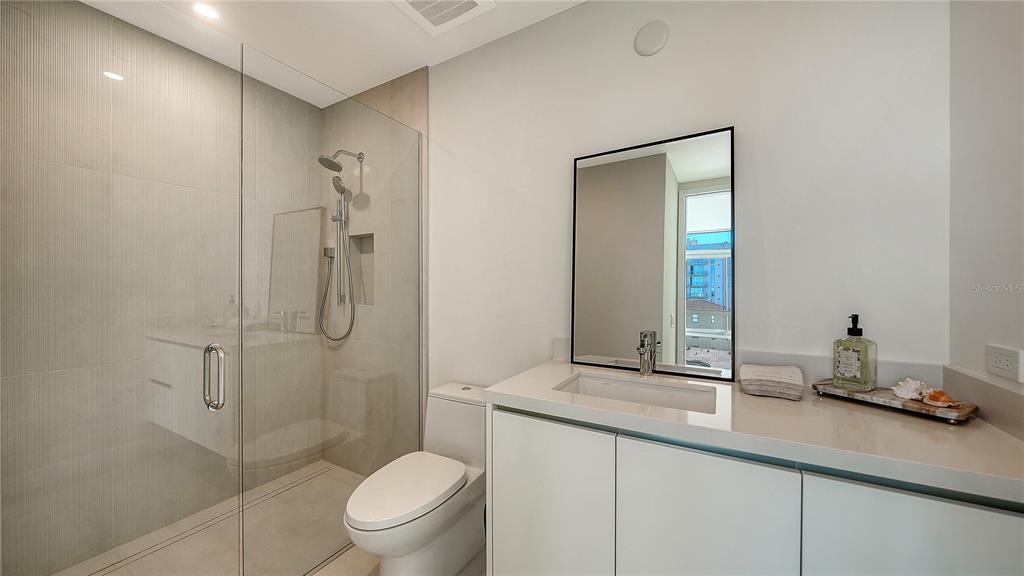 111 Golden Gate Point, Unit 201 Sarasota, FL 34236 - Photo 28 of 64 a bathroom with a granite countertop sink a toilet and shower
