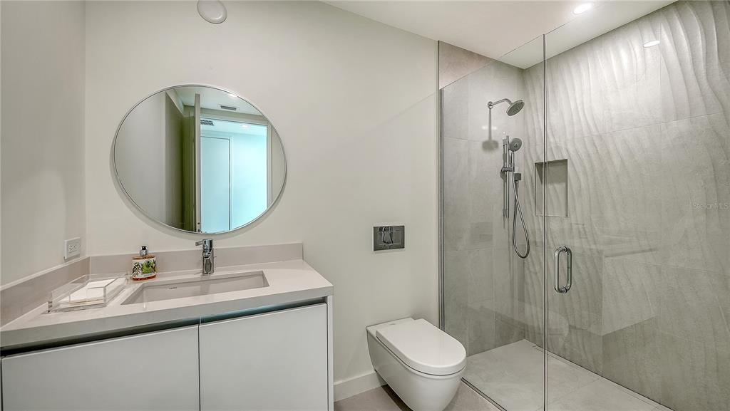 111 Golden Gate Point, Unit 201 Sarasota, FL 34236 - Photo 30 of 64 a bathroom with a toilet sink shower and mirror