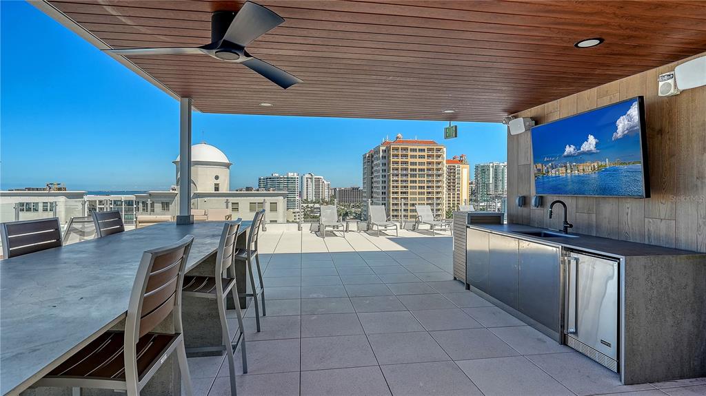 111 Golden Gate Point, Unit 201 Sarasota, FL 34236 - Photo 59 of 64 a kitchen with stainless steel appliances kitchen island granite countertop a table chairs and a refrigerator