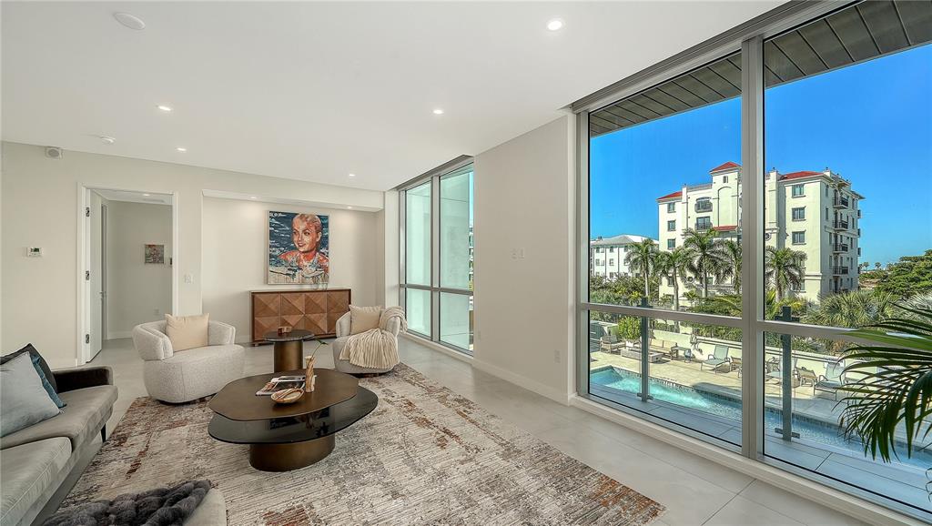 111 Golden Gate Point, Unit 201 Sarasota, FL 34236 - Photo 9 of 64 a living room with furniture and a floor to ceiling window