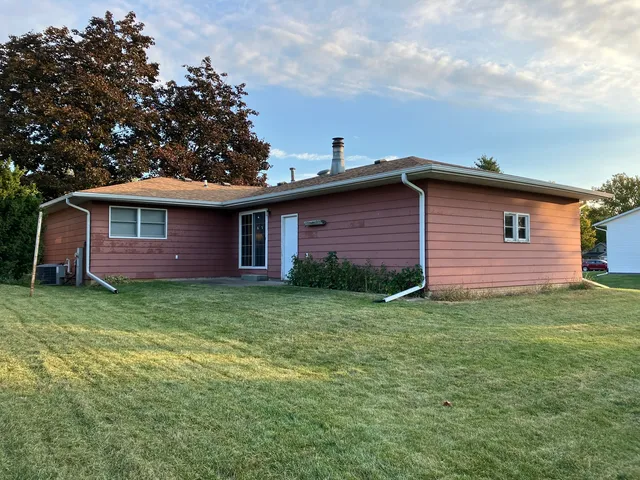 a view of a house with backyard and trees