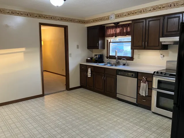 a kitchen with stainless steel appliances granite countertop a stove a sink and a refrigerator