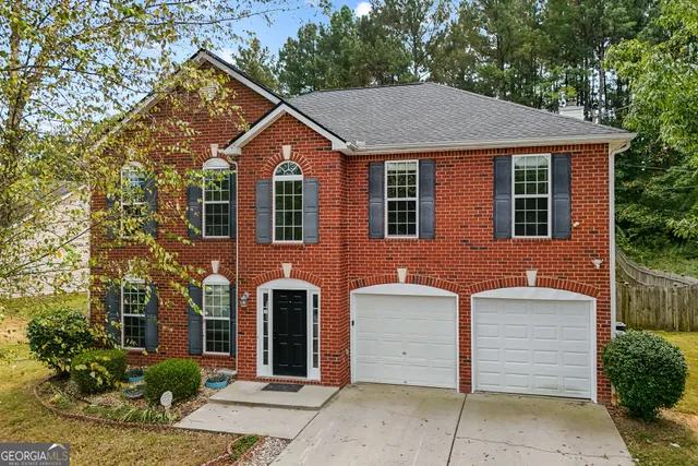 a front view of a house with a garden
