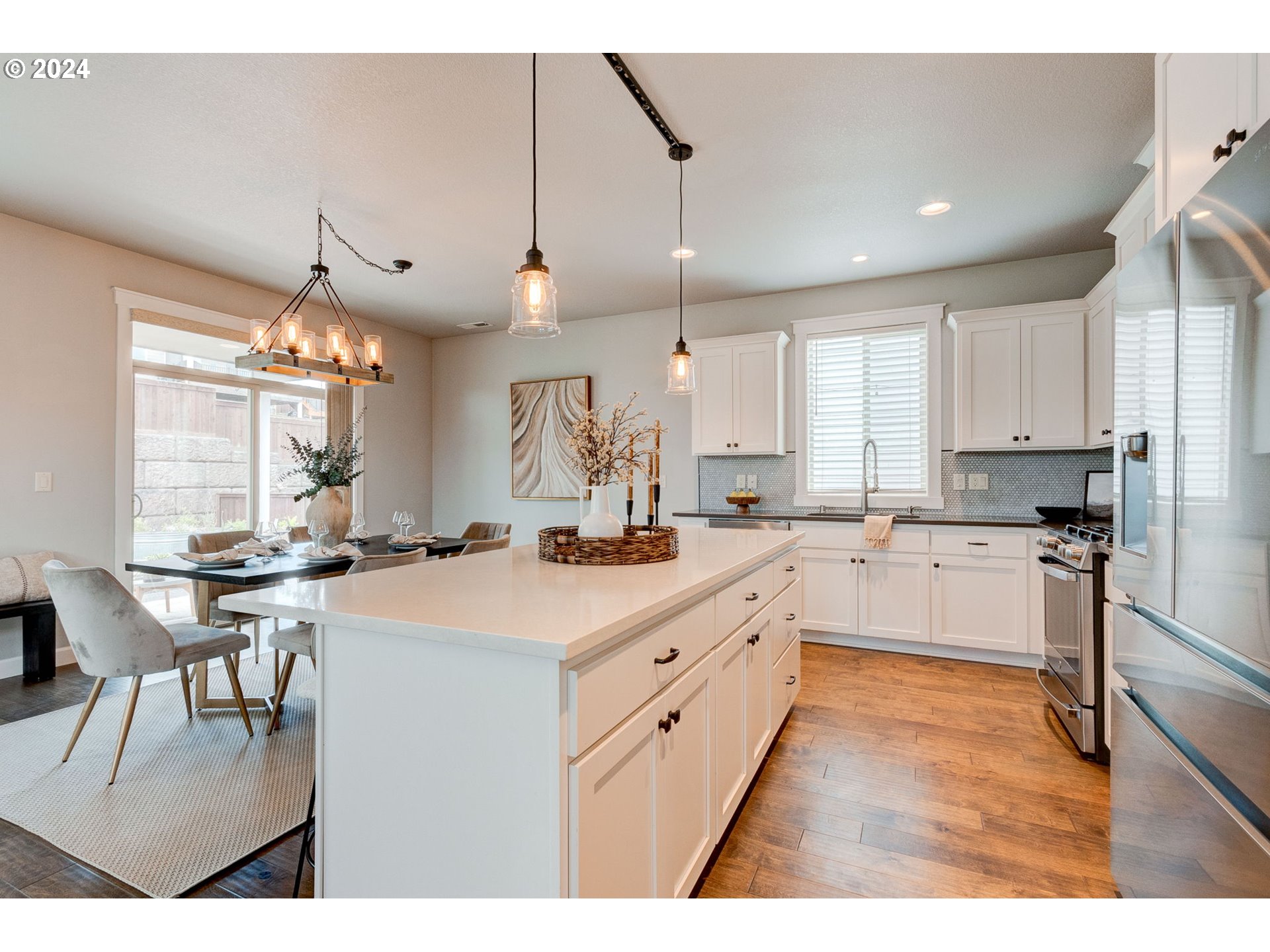 3293 North 10th Street Ridgefield, WA 98642 - Photo 16 of 47 a large kitchen with kitchen island a sink a stove a dining table and chairs
