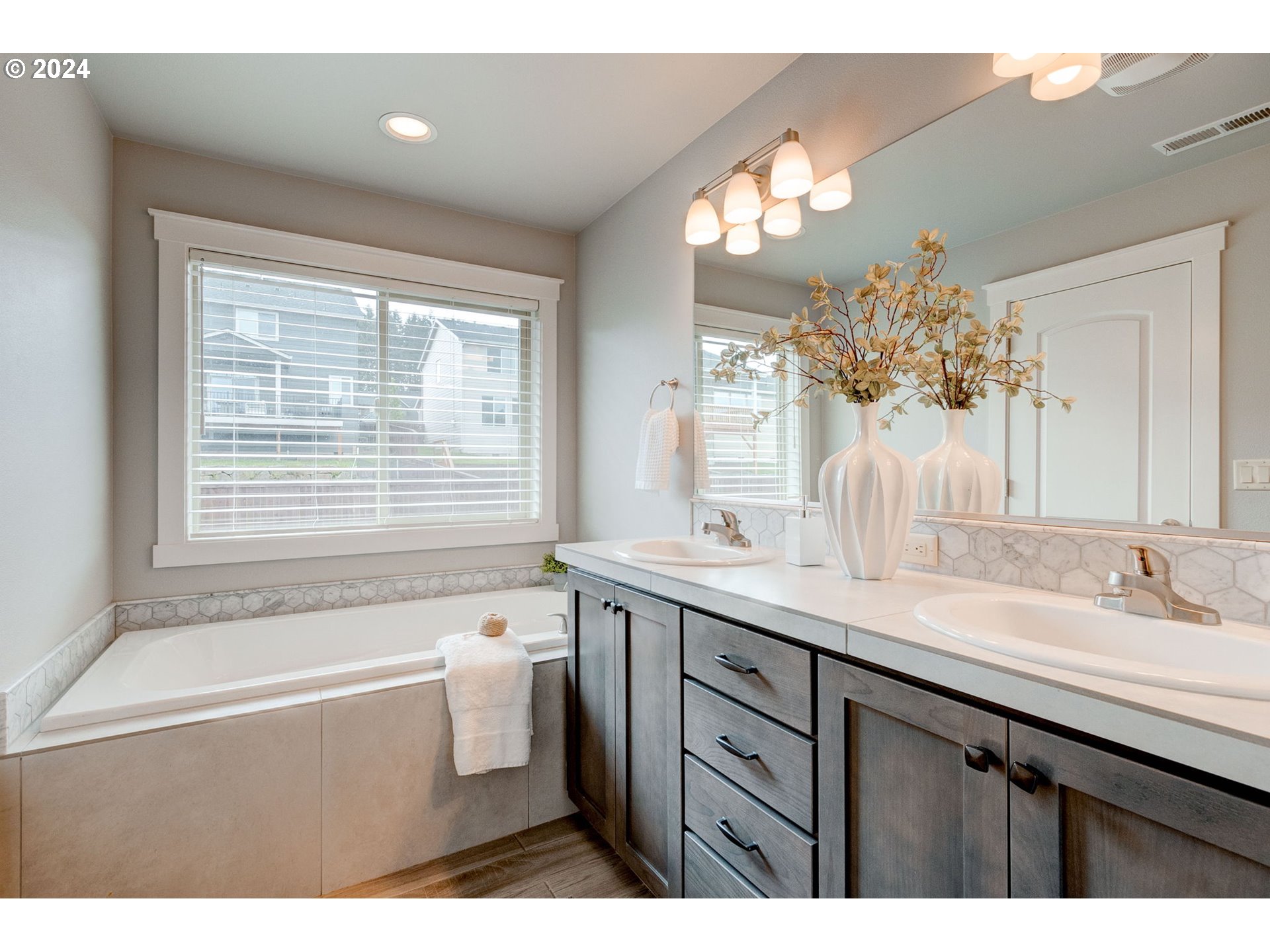 3293 North 10th Street Ridgefield, WA 98642 - Photo 33 of 47 a spacious bathroom with a granite countertop sink a large mirror a bathtub and window