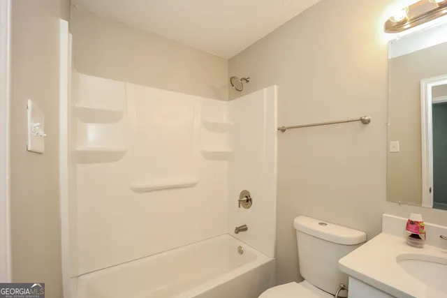 a bathroom with a bathtub shower sink vanity and toilet
