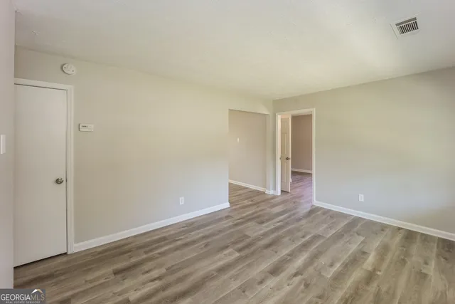 a view of an empty room with wooden floor