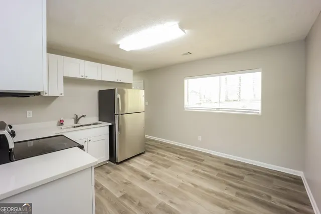 a kitchen with a refrigerator and a stove top oven