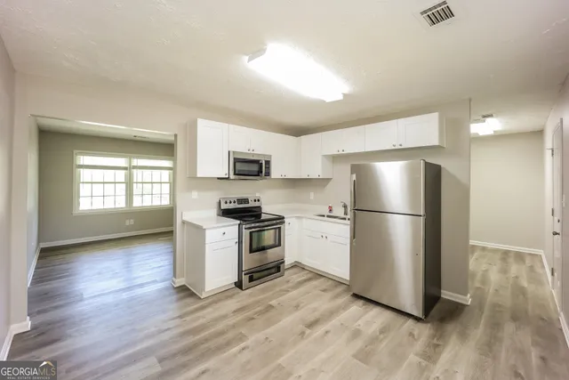 a kitchen with a refrigerator and a stove top oven