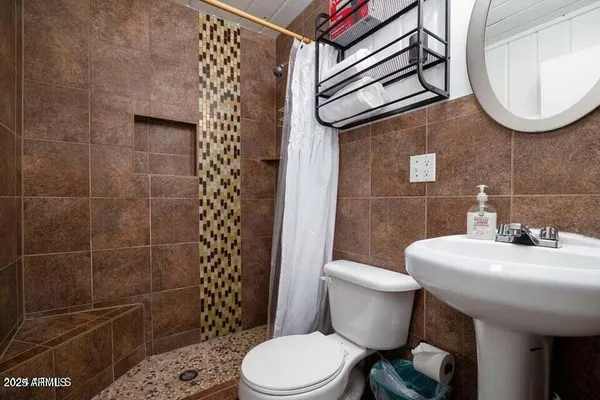 a bathroom with a sink toilet and a mirror