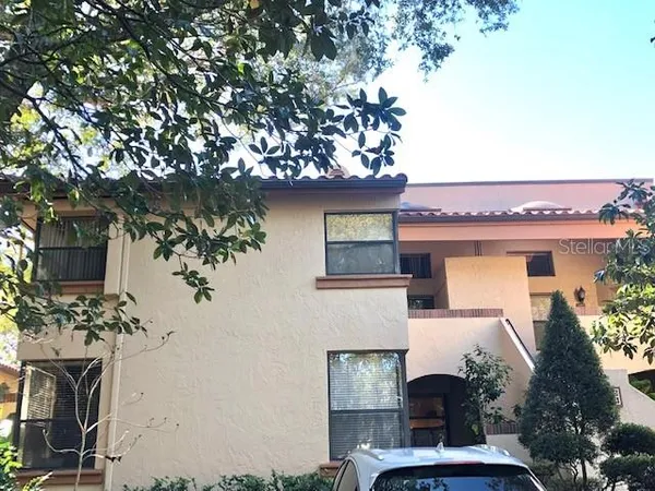 a white house with a yard and table and chairs under an umbrella