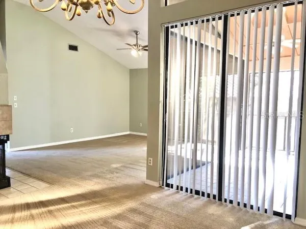 a view of an empty room with a fireplace and a window