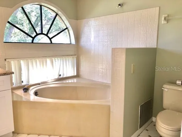 a bathroom with a tub a large window and a sink