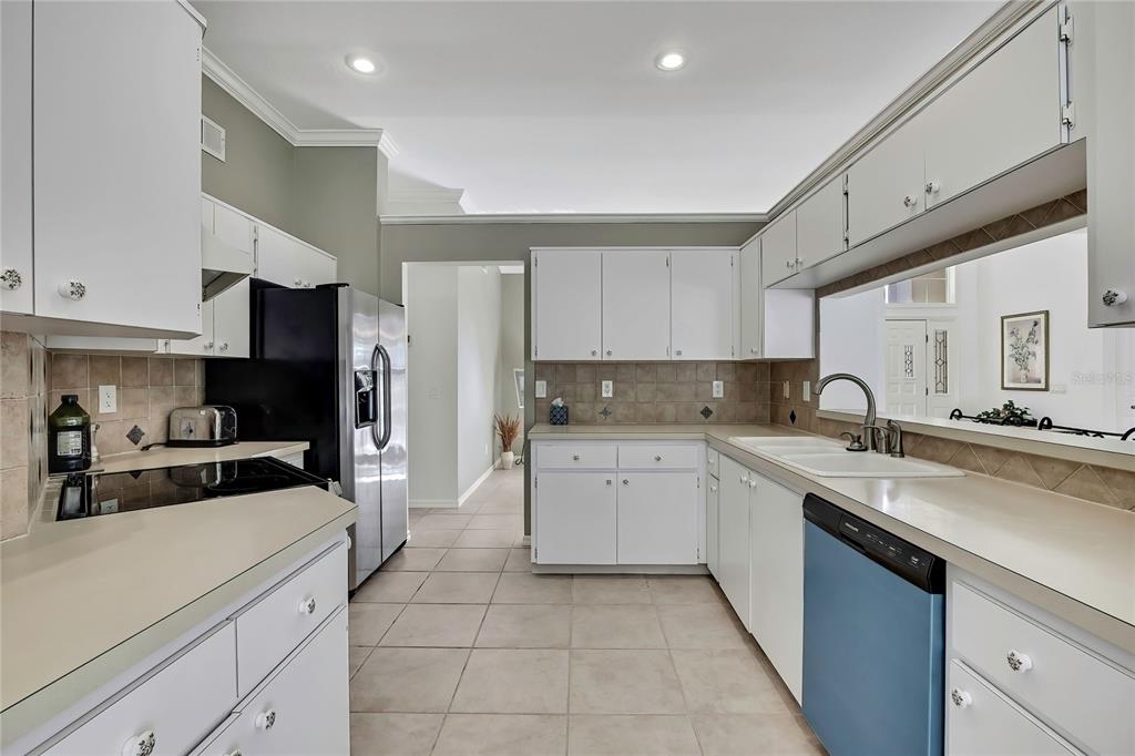 3275 West Daffodil Drive Dunnellon, FL 34433 - Photo 23 of 67 a kitchen with a sink white cabinets and stainless steel appliances