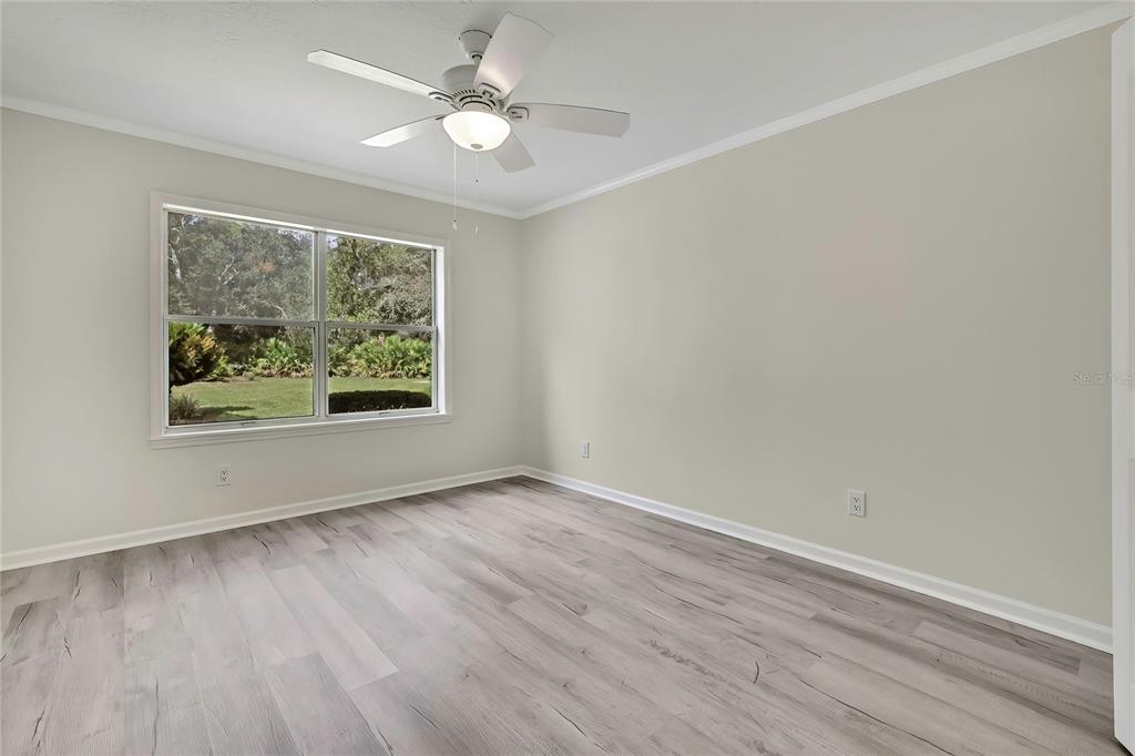 3275 West Daffodil Drive Dunnellon, FL 34433 - Photo 40 of 67 an empty room with wooden floor chandelier fan and windows