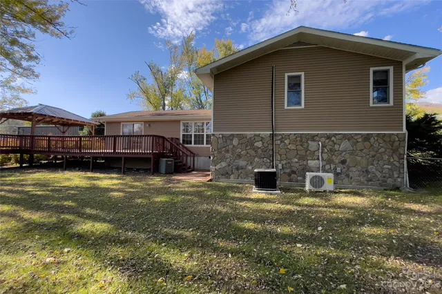 a view of a house with a large tree and a yard