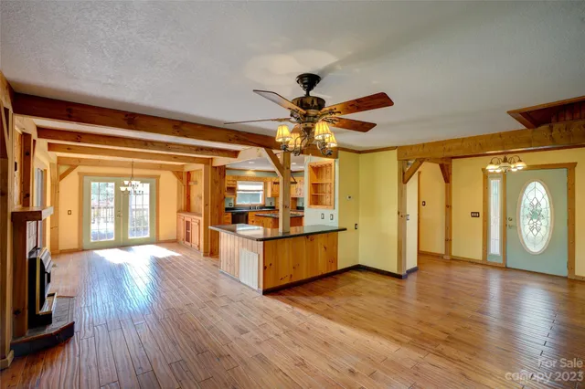 a view of a big room with wooden floor and windows