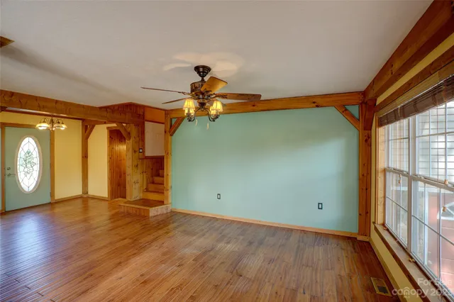 a view of a room with wooden floor and windows