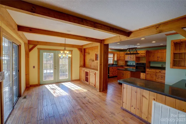 a view of a kitchen with kitchen island wooden floor and stainless steel appliances