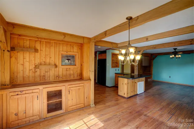 a view of a kitchen with stainless steel appliances granite countertop a stove and a wooden floors