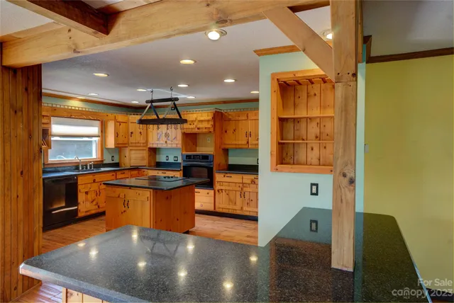 a kitchen with stainless steel appliances granite countertop a sink a stove top oven a counter space and cabinets