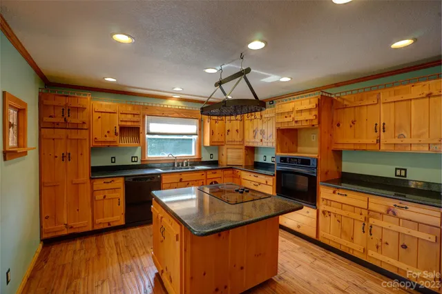 a kitchen with stainless steel appliances granite countertop sink stove top oven and cabinets