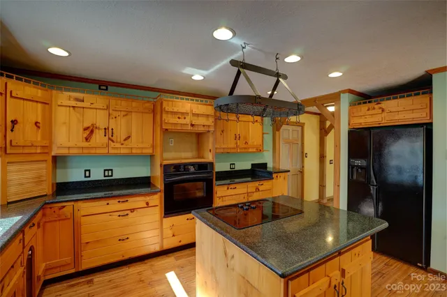 a kitchen with stainless steel appliances granite countertop a sink a stove and a refrigerator