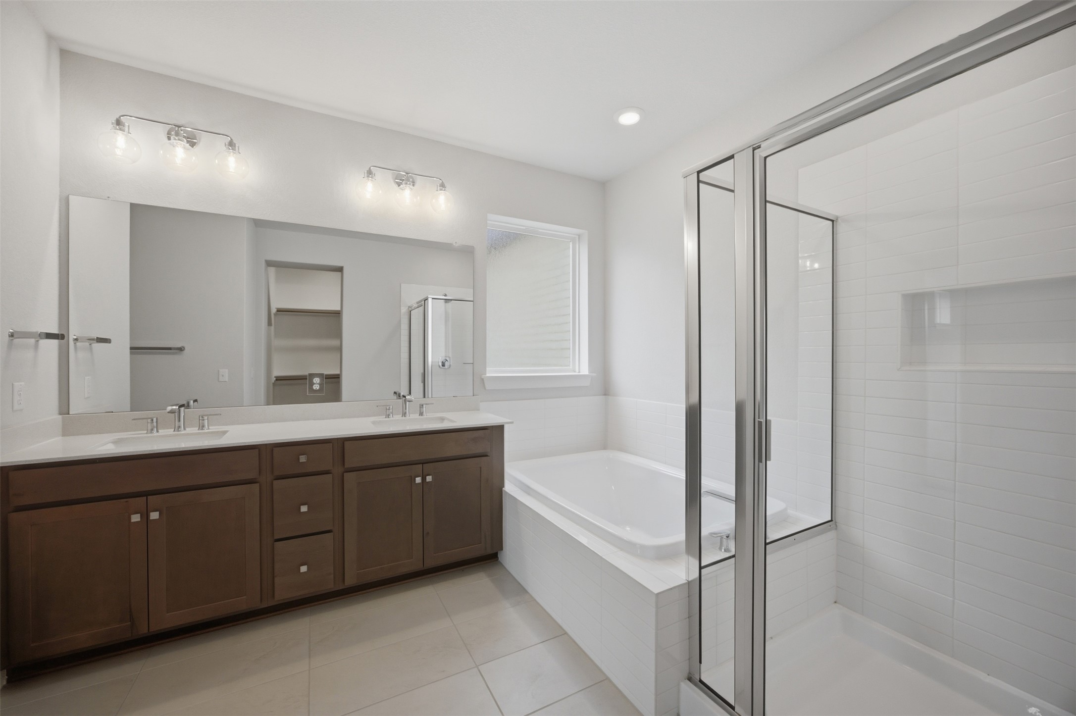 2101 Little Snake Way Georgetown, TX 78633 - Photo 22 of 37 A well-appointed primary bathroom features a dual vanity, a soaking tub, and a separate glass-enclosed shower.