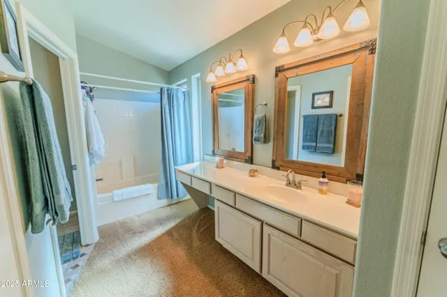 a bathroom with a double vanity sink mirror and shower