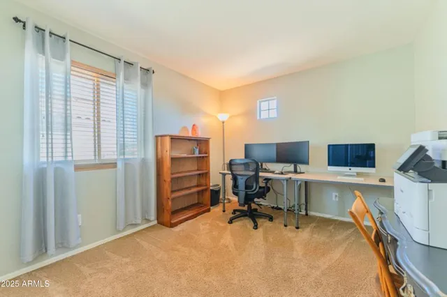 a view of a workspace with furniture and a window