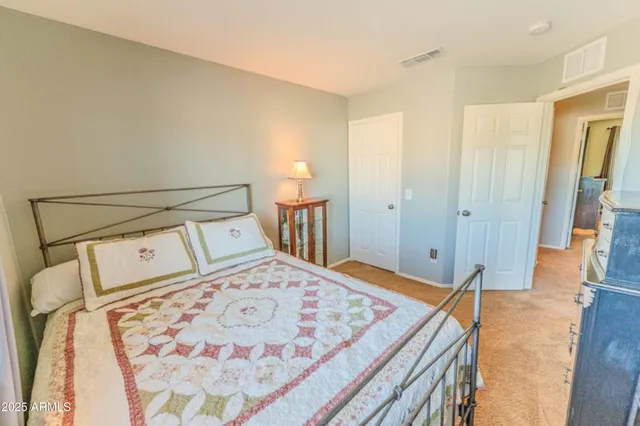 a bedroom with a bed and a flat tv screen on a dresser