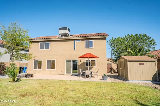 a view of a house with a yard patio and fire pit