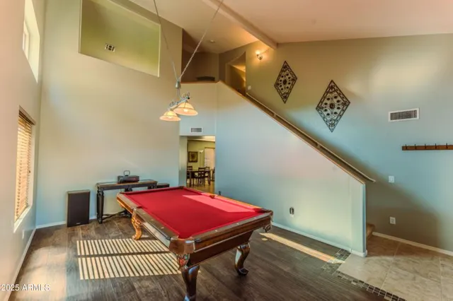 a living room with furniture pool table and window