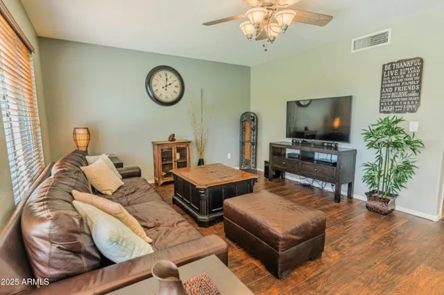 a living room with furniture a flat screen tv and a window