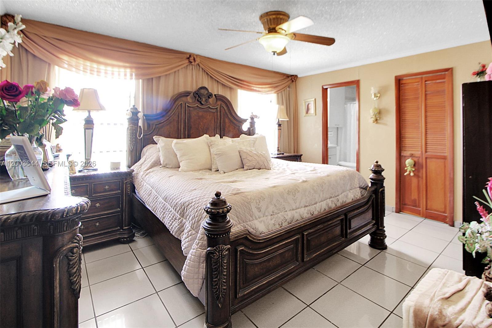19100 Southwest 125th Avenue Miami, FL 33177 - Photo 22 of 46 a bedroom with a bed and a chandelier
