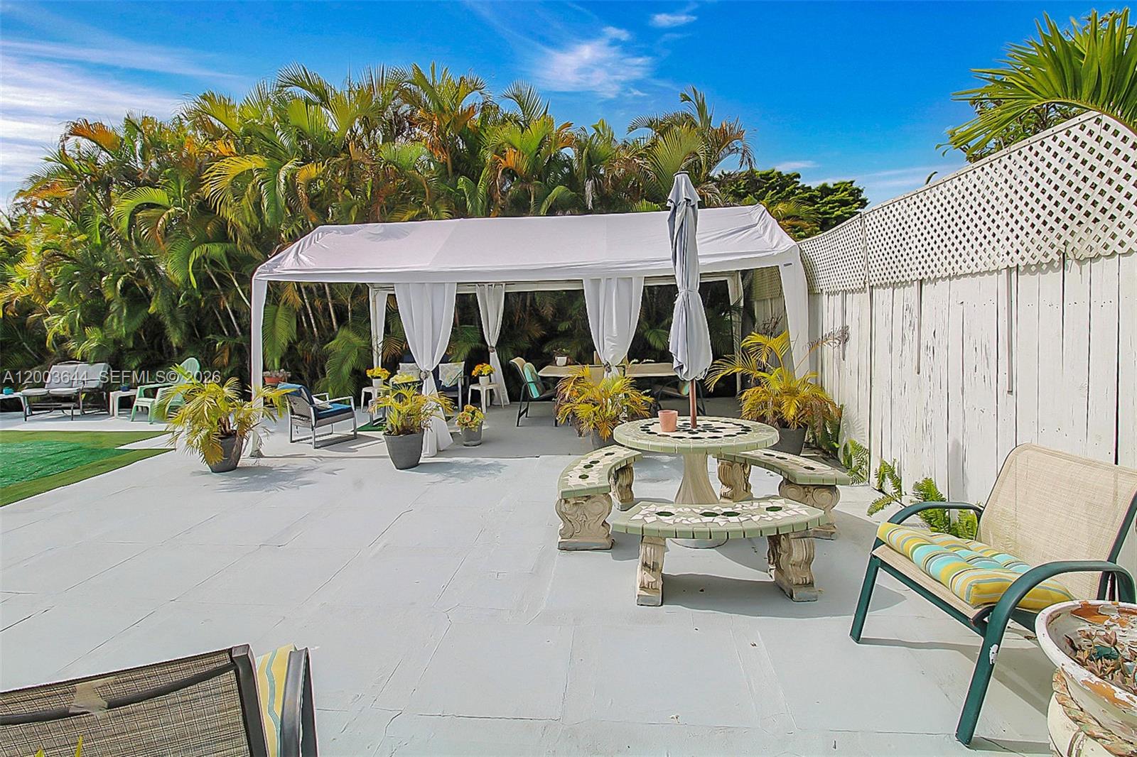 19100 Southwest 125th Avenue Miami, FL 33177 - Photo 31 of 46 a view of a patio with table and chairs under an umbrella with a fire pit