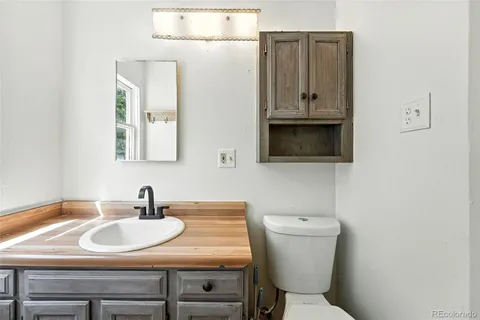 a bathroom with a sink toilet and mirror