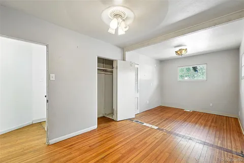 a view of empty room with wooden floor