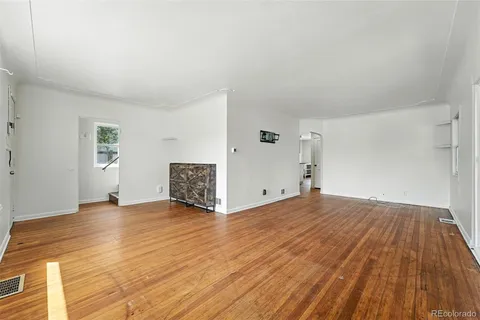 a view of empty room with wooden floor